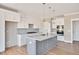 Modern kitchen with white cabinets, gray island, and quartz countertops at 7723 Barefoot Rd, Fuquay Varina, NC 27526