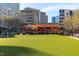 Ground-level view of a community green space with restaurant and city buildings in the background at 806 Tyrrell Rd, Raleigh, NC 27609