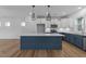 Open kitchen with a large blue island, white cabinets, stainless steel appliances, and modern lighting at 930 Allen Pk Dr, Raleigh, NC 27604