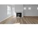 Bright living room with wood-look flooring, a modern fireplace, and abundant natural light from multiple windows at 930 Allen Pk Dr, Raleigh, NC 27604