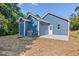 Backyard showing blue siding with white trim, concrete patio, and wooded area, perfect for outdoor living at 0 Cedar Grove Church Rd Rd, Roxboro, NC 27574
