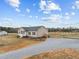 Well-maintained home showcasing a gravel driveway, covered porch, and neat landscaping for a welcoming curb appeal at 117 Hinshaw Shop Rd, Liberty, NC 27298
