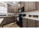 Modern kitchen with dark wood cabinets and black appliances at 117 Hinshaw Shop Rd, Liberty, NC 27298