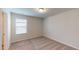 Compact bedroom features carpet, neutral walls, and a window for natural light at 120 Anise Tree Way, Clayton, NC 27527