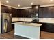 Modern kitchen boasts stainless steel appliances, granite countertops, dark cabinetry and a convenient kitchen island at 120 Anise Tree Way, Clayton, NC 27527