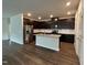 Modern kitchen boasts stainless steel appliances, granite countertops, dark cabinetry and a convenient kitchen island at 120 Anise Tree Way, Clayton, NC 27527