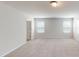 Carpeted loft with multiple windows, a door, and views to the hall at 120 Anise Tree Way, Clayton, NC 27527