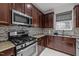 Close-up of kitchen area featuring stainless steel appliances, granite countertops, and tile backsplash at 12420 Tetons Ct, Durham, NC 27703