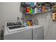 This is a practical laundry room with a washer, dryer, and storage shelves at 12420 Tetons Ct, Durham, NC 27703