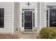 Black front door with sidelights and charming planters at 203 Anniston Ct, Cary, NC 27519