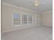 Bright living room with wall-to-wall carpeting, large windows, and deck access at 203 Anniston Ct, Cary, NC 27519