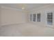 Spacious living room with wall-to-wall carpeting, large windows, and access to a deck at 203 Anniston Ct, Cary, NC 27519