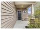 Covered front porch with stone accents and stylish black front door at 245 E Webber Ln, Clayton, NC 27527