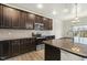 Kitchen features stainless steel appliances, granite countertops and dark cabinets, plus a kitchen island with sink and faucet at 245 E Webber Ln, Clayton, NC 27527