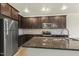 Kitchen features stainless steel appliances, granite countertops and dark cabinets, plus a kitchen island with sink and faucet at 245 E Webber Ln, Clayton, NC 27527