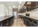 Kitchen features stainless steel appliances, granite countertops and dark cabinets, plus a kitchen island with sink and faucet at 245 E Webber Ln, Clayton, NC 27527