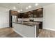 Well-lit kitchen with dark cabinets, stainless steel appliances and granite countertops, plus island sink and faucet at 245 E Webber Ln, Clayton, NC 27527