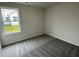 Bright bedroom with gray carpeting and a window overlooking the backyard at 395 Magnolia Run Way, Benson, NC 27504