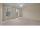 Spacious bedroom with neutral carpeting and two windows at 4532 Malvern Rd, Durham, NC 27707
