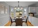 Eat-in kitchen with white cabinets, breakfast nook, and hardwood floors at 4532 Malvern Rd, Durham, NC 27707