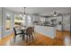 Eat-in kitchen with white cabinets, breakfast nook, and hardwood floors at 4532 Malvern Rd, Durham, NC 27707