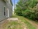 The exterior of the home featuring a concrete patio and lush green trees at 5110 Chipstone Dr, Raleigh, NC 27610