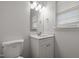 Clean bathroom featuring a single vanity, updated lighting, and a modern water-efficient toilet at 5110 Chipstone Dr, Raleigh, NC 27610