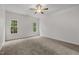 Bright bedroom with plush carpeting, ceiling fan, and double windows overlooking outdoor greenery at 5110 Chipstone Dr, Raleigh, NC 27610