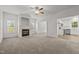 Open-concept living room with fireplace, carpet floors, and view to the kitchen at 5110 Chipstone Dr, Raleigh, NC 27610