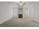 Bright living room featuring neutral carpet, ceiling fan, and fireplace at 5110 Chipstone Dr, Raleigh, NC 27610