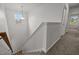 Bright staircase with a window, white walls, carpeted steps, and a view from the top looking down at 5110 Chipstone Dr, Raleigh, NC 27610
