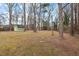 Expansive backyard featuring a detached storage shed, mature trees, and plenty of space for outdoor activities at 5232 Guess Rd, Durham, NC 27712