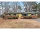 Charming single-story home with a brick foundation and a bright yellow front door at 5232 Guess Rd, Durham, NC 27712