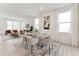 Bright, open dining room with modern glass table, stylish chairs, and adjacent living area at 528 Gainer Dr # 8, Raleigh, NC 27610