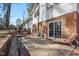 Back patio features lounge seating, brick facade on house and grill on gravel at 5410 Thayer Dr, Raleigh, NC 27612