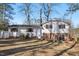 Backyard view shows large lawn area, mature trees, and rear house facade with brick accent at 5410 Thayer Dr, Raleigh, NC 27612