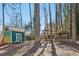 Backyard view with playhouse, swing set, and mature trees at 5410 Thayer Dr, Raleigh, NC 27612