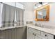 Renovated bathroom with shaker cabinets, white marble countertop, wood-trimmed mirror, and gray accent walls at 5410 Thayer Dr, Raleigh, NC 27612