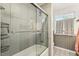 Bathroom with tiled shower, glass doors, patterned floors and a vanity providing a clean and stylish space at 5410 Thayer Dr, Raleigh, NC 27612