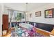 Sunlit dining room with stylish decor, hardwood floors, and colorful transparent chairs at 5410 Thayer Dr, Raleigh, NC 27612