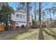 Exterior house view showing partial brick facade, mature trees, and well maintained lawn at 5410 Thayer Dr, Raleigh, NC 27612