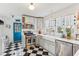 Stylish kitchen boasts stainless appliances, light gray cabinetry, and checkerboard flooring at 5410 Thayer Dr, Raleigh, NC 27612