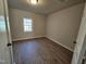 Cozy bedroom features modern floors and natural light from a window at 611 Rowland St, Henderson, NC 27536