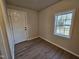 Bright bedroom with a window, white door, and modern wood floors at 611 Rowland St, Henderson, NC 27536