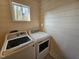 Bright laundry room with shiplap walls and modern, stainless steel washer and dryer at 611 Rowland St, Henderson, NC 27536