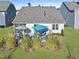 Aerial view of the backyard featuring dual patio seating areas, complemented by green grass and mature shrubs at 612 Sweet Pine Ln, Knightdale, NC 27545