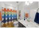 Well-lit bathroom with a modern vanity, framed mirror, and colorful shower curtain at 612 Sweet Pine Ln, Knightdale, NC 27545