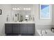 Modern bathroom with double vanity, large mirror, and a separate bathtub at 612 Sweet Pine Ln, Knightdale, NC 27545