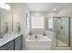 Elegant bathroom featuring a soaking tub, a glass-enclosed shower, and double sinks at 612 Sweet Pine Ln, Knightdale, NC 27545