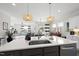 Modern kitchen with stainless appliances, a large island with sink, and stylish pendant lighting at 612 Sweet Pine Ln, Knightdale, NC 27545